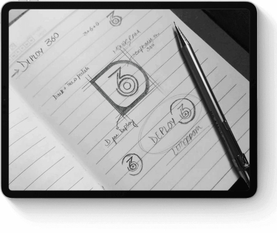 A notebook page displaying sketched logo designs labeled "DEPLOY 360," with typography notes. A pen lies diagonally across the page. Black and white tones.
